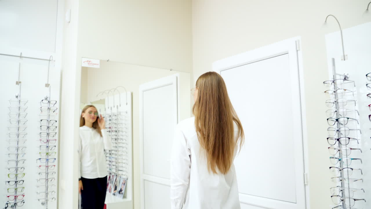 Young woman choosing eyeglasses. Happy woman choosing glasses at optics store