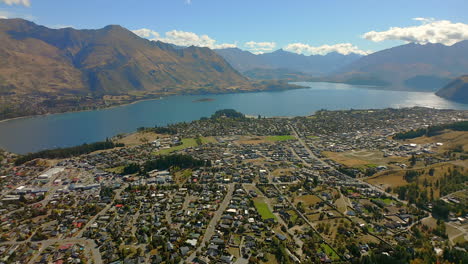 wānaka village town community - aerial tilt up to reveal lake wanaka and the remarkables mountain range