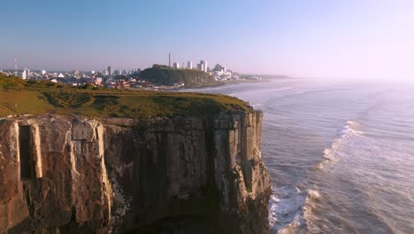 Hermosa-Toma-Cinematográfica-En-Movimiento-Aéreo-De-Altos-Acantilados-En-El-Océano-Atlántico,-Unidad-De-Conservación-Brasileña-En-Torres,-Rio-Grande-Do-Sul