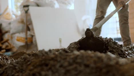 builders hands with hoe mixing cement at renovation site