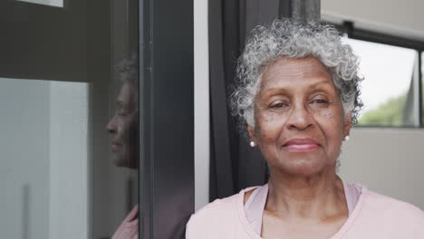 Retrato-De-Una-Feliz-Mujer-Afroamericana-Sonriendo-Junto-A-La-Ventana,-Espacio-Para-Copiar,-Cámara-Lenta