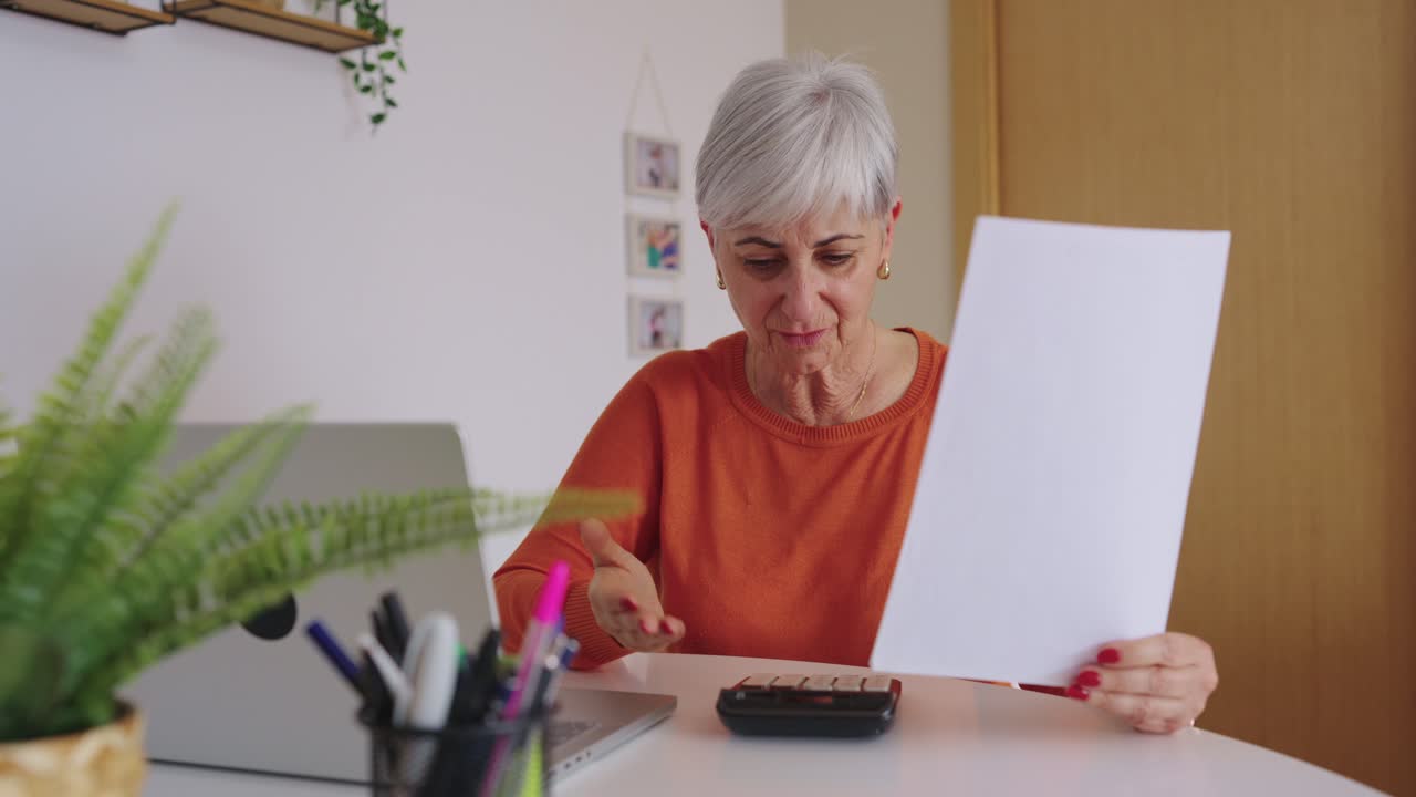 Donna Anziana che Calcola le Finanze e Rivede Documenti a Casa