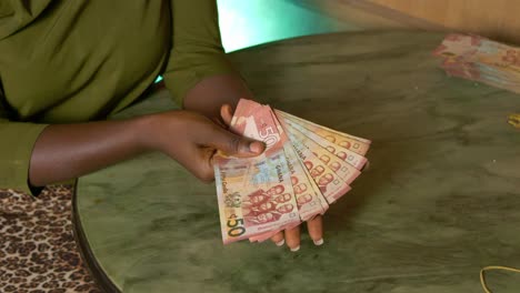 black female hands close up holding ghanaian cedi paper money bills currency of ghana republic in slow motion