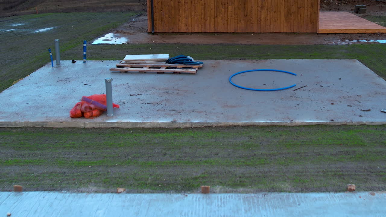 bajo vuelo aéreo sobre cimientos de hormigón en el sitio de construcción en días nublados