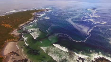 aerial view of waves reaching a shore at beach