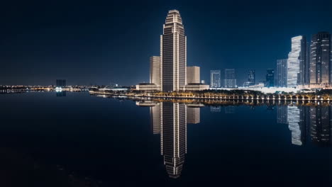 night cityscape with illuminated buildings reflected in water