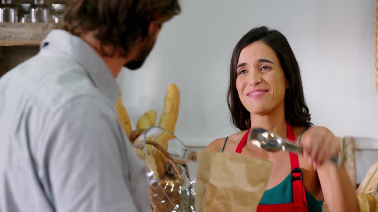 personal femenino que sirve pan en una panadería