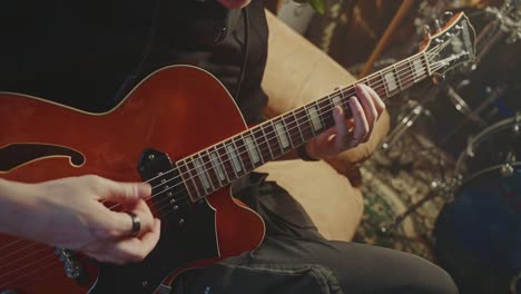 person playing a red jazz guitar