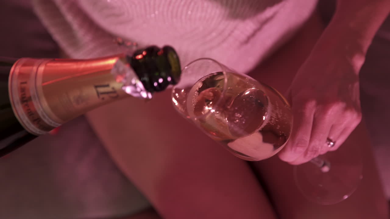 Woman pouring champagne in a glass and drinking it