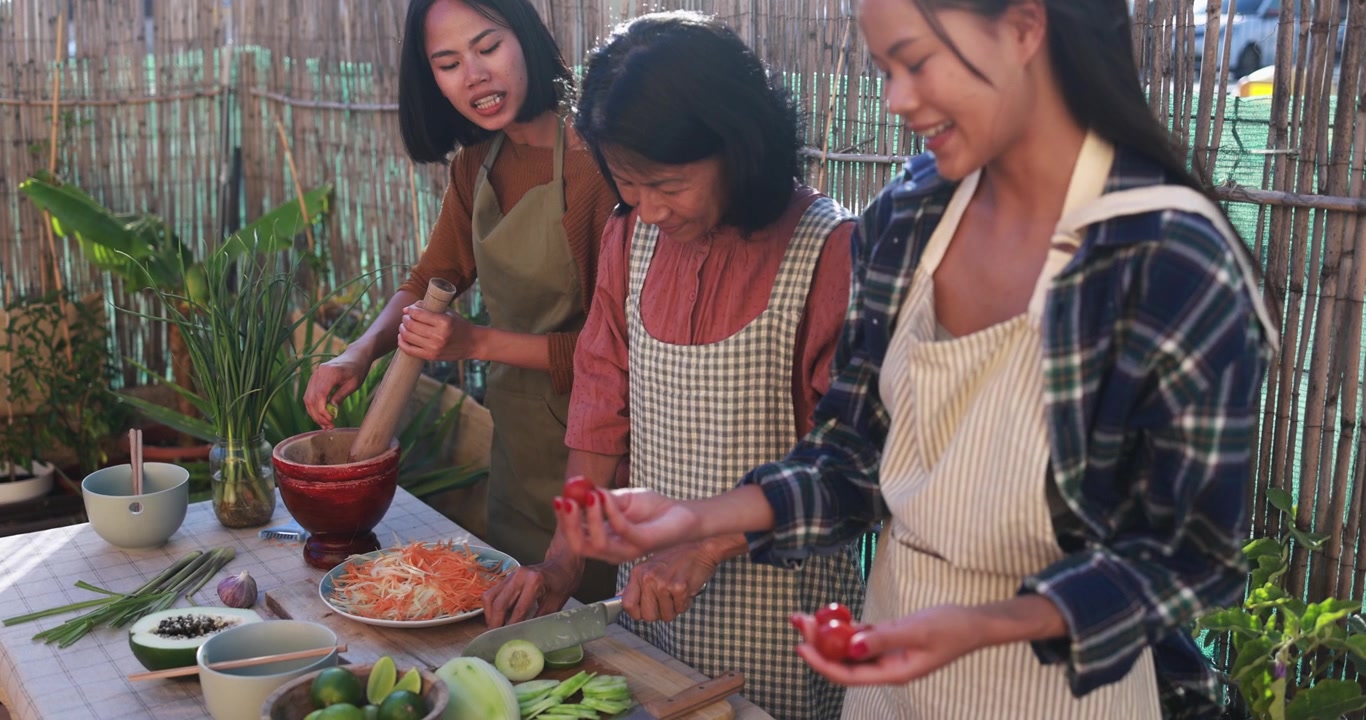 アジア人女性たちが屋外キッチンで一緒に伝統的な料理を準備している