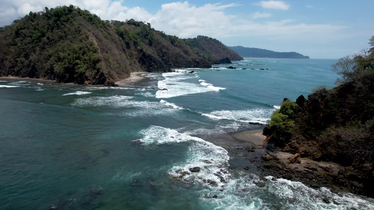 Waves crashing toward themselves in between bay and ocean in Costa Rica