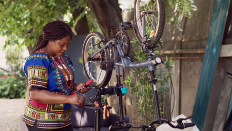 mujer prepara herramientas para una bicicleta rota