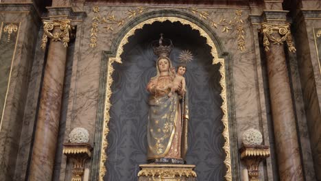 statue of virgin mary with child in an ornate gilded niche surrounded by marble columns