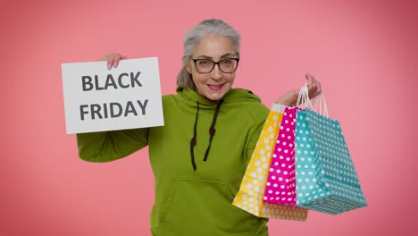 Elderly-granny-woman-showing-Black-Friday-inscription-banner-text,-advertising-discounts,-low-prices