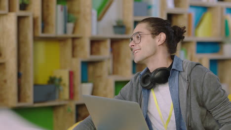 Joven-Estudiante-Caucásico-Compartiendo-Ideas-Disfrutando-De-Una-Conversación-Discutiendo-Información-Del-Proyecto-Con-Colegas-Que-Usan-Gafas-En-Un-Colorido-Y-Moderno-Lugar-De-Trabajo-De-Oficina