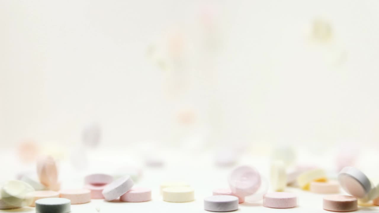 Reverse Slow Motion of candy tablets bouncing and tumbling out of frame moving backwards