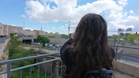 mujer tomando una foto de la ciudad vieja de jerusalem