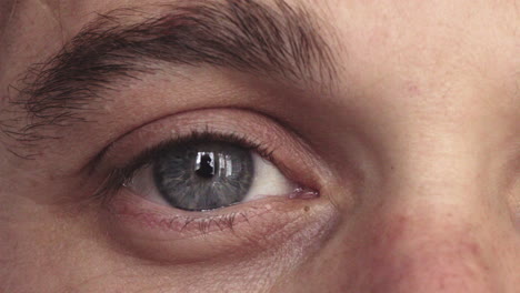 close-up-of-man-blue-eye-looking-at-camera-tracking-reflection-on-iris