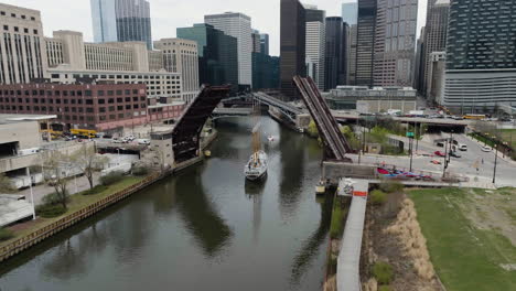 Aerial-view-of-a-schooner-ship-driving-through-a-raised-bridge,-springtime-in-Chicago,-USA