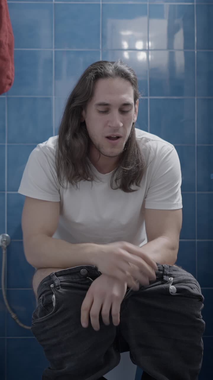 Uomo che soffre di mal di stomaco sul water