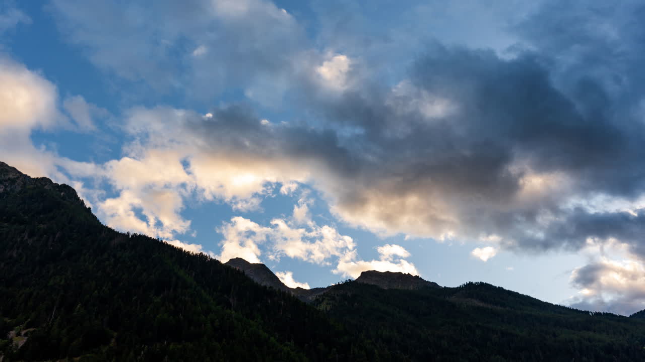 Fast-moving clouds linger above the serene Alps, a breathtaking view
