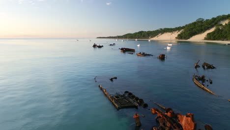 Closeup-Aerial-Drone-Fly-Shipwreck-old-sank-ship,-pristine-beach-island-skyline-landscape,-Tangalooma,-Moreton-Island-Australia