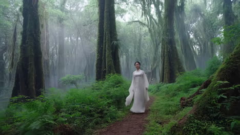 a woman in a white traditional dress walking through a mystical misty green forest