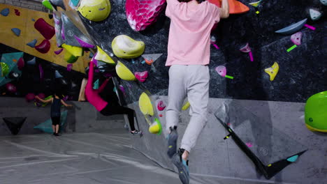 adolescentes haciendo bouldering en un gimnasio