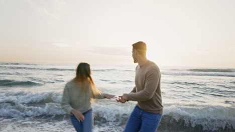 Pareja,-Corriendo-Hacia-El-Océano-Y-Tomados-De-La-Mano