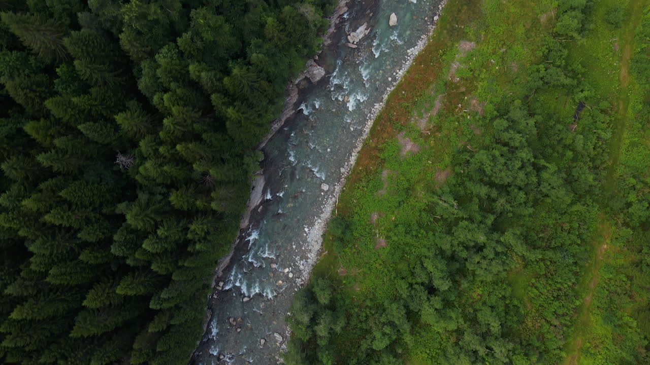 Drone flying over river and forest in summer in Norway