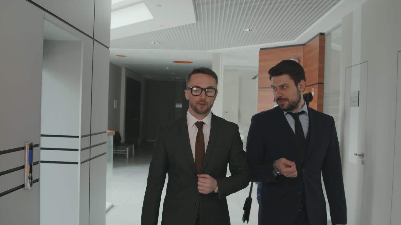 Male Lawyers in Suits Walking through Office