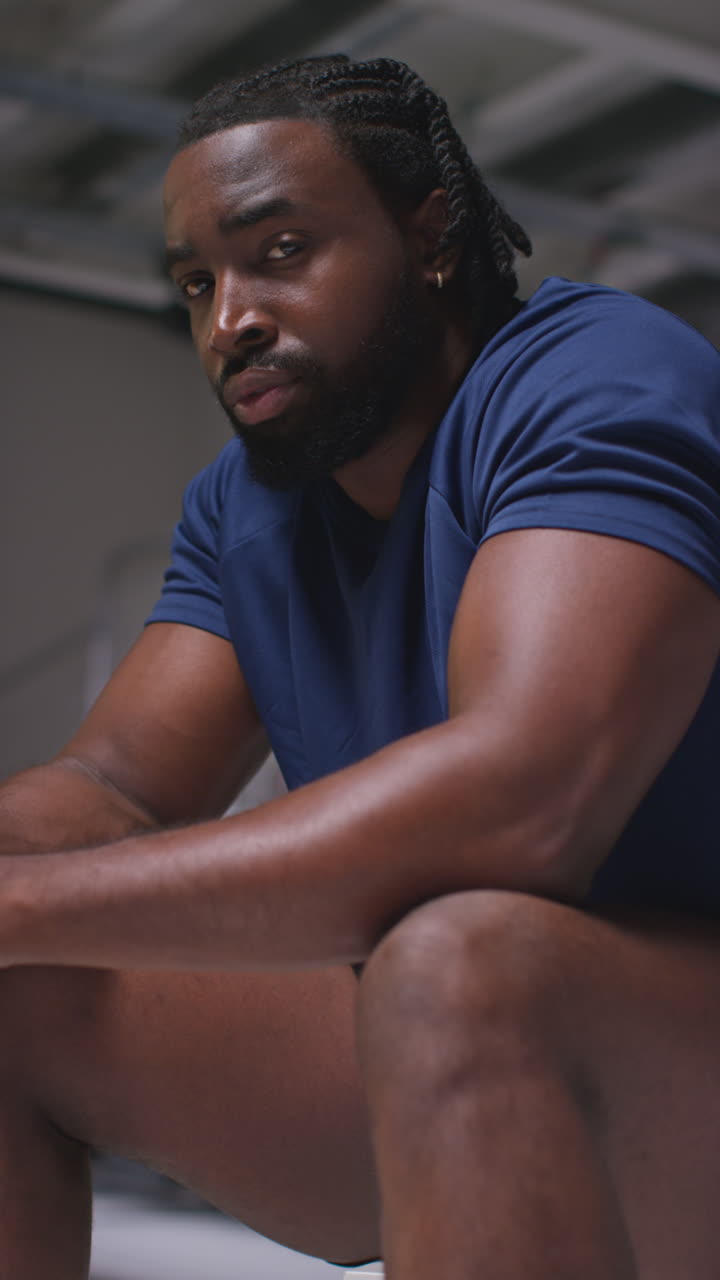 Vertical Video Portrait Of Determined Male Athlete Sport Training In Gym Sitting And Concentrating In Changing Room With Focused Expression 1
