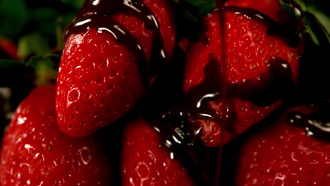 melted chocolate pouring over strawberries