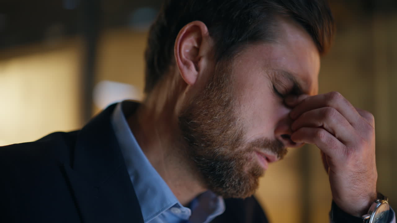 Portrait manager working late at dark workspace. Bearded businessman eyestrain