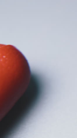 motion above diagonal cutting pliers with red and black handles lying on white surface extreme close view