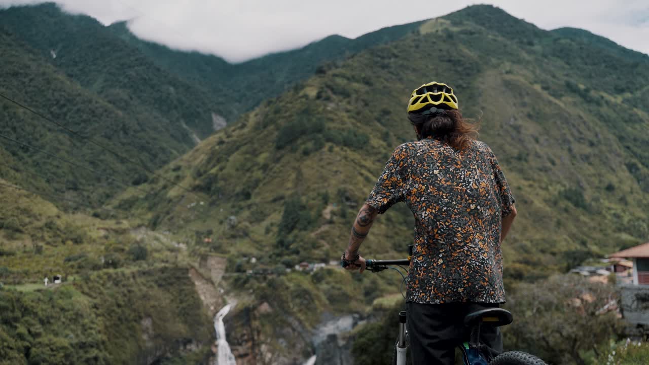 바뇨스 에콰도르에서 자전거 루트 투어 중 폭포를 바라보는 바이커