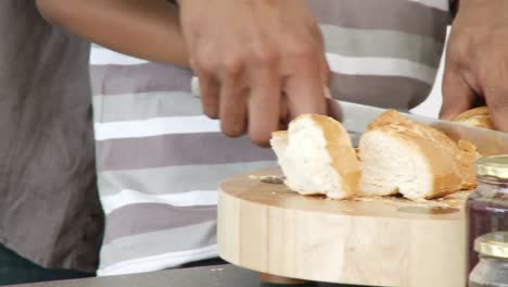 close up of father and son cutting bread in the kitchen