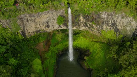 bridal veil fall in rock canyon with pool below, new zealand, aerial