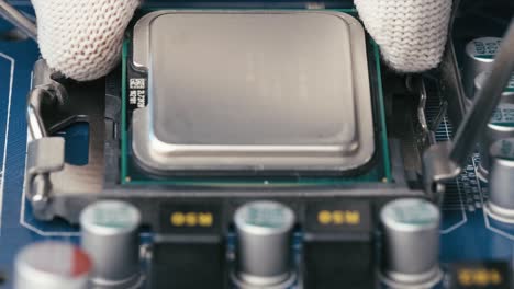 guantes blancos instalando el procesador de microchip cpu en el zócalo de la placa base, primer plano extremo