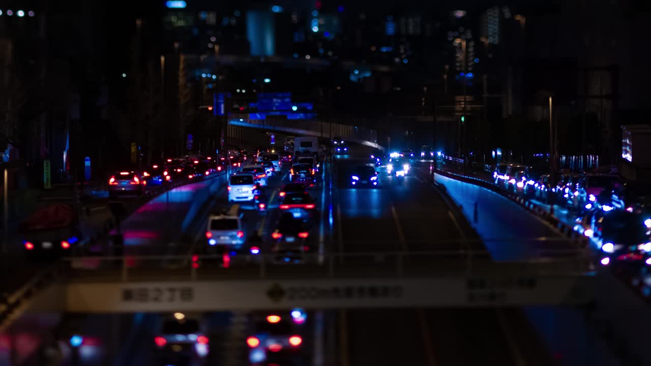 En natt-timelapse av et miniatyrkork i en bygate i Tokyo