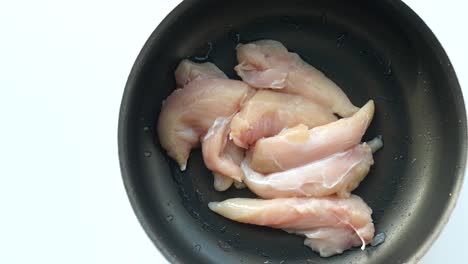 pecho de pollo crudo en una sartén