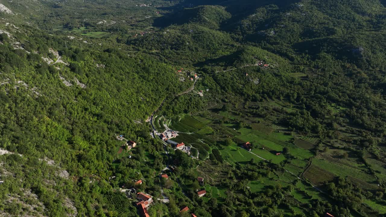 Aerial: small village in Montenegro mountains during the day around Lake Skadar, orbit drone shot