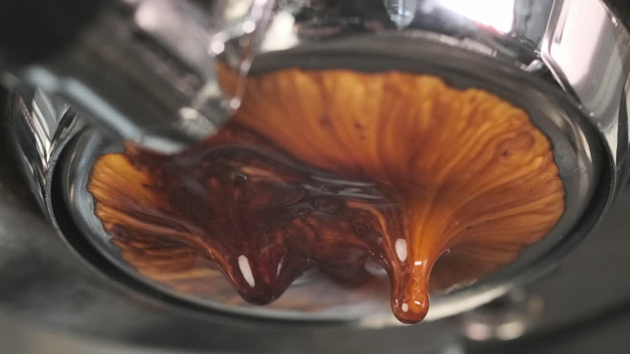 Golden coffee drips smoothly from a machine, creating a warm and enchanting flow of rich liquid