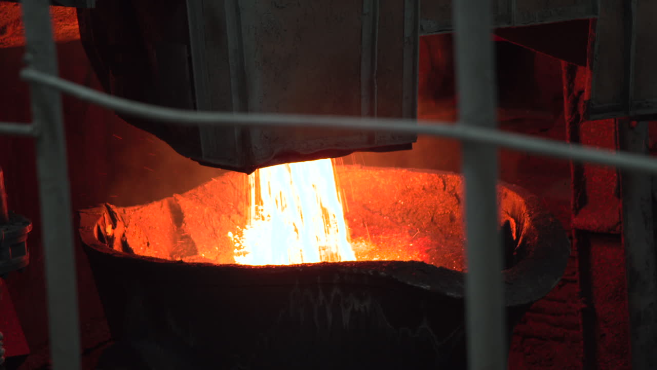Colata di metallo fuso da siviera in fonderia industriale