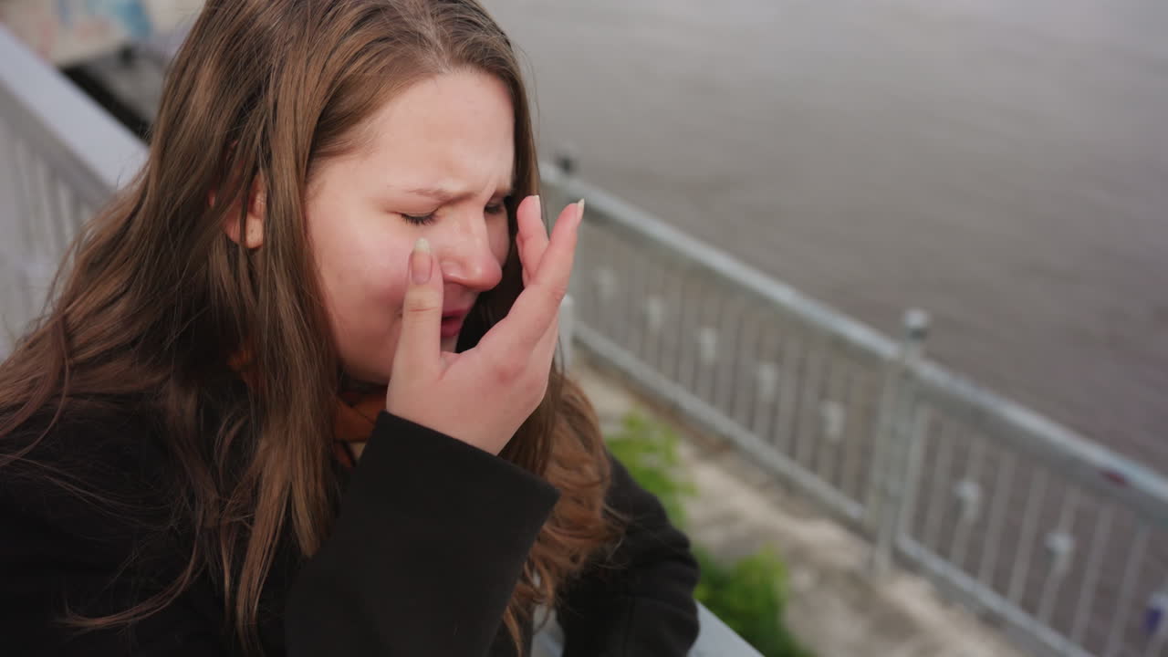 Aerial view shows calm river surface surrounded by iron handrails and green vegetation, sunlight reflecting softly on water while creating peaceful atmosphere and safety along quiet riverside walkway