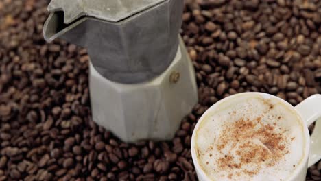 cafetera con granos de café y taza de café