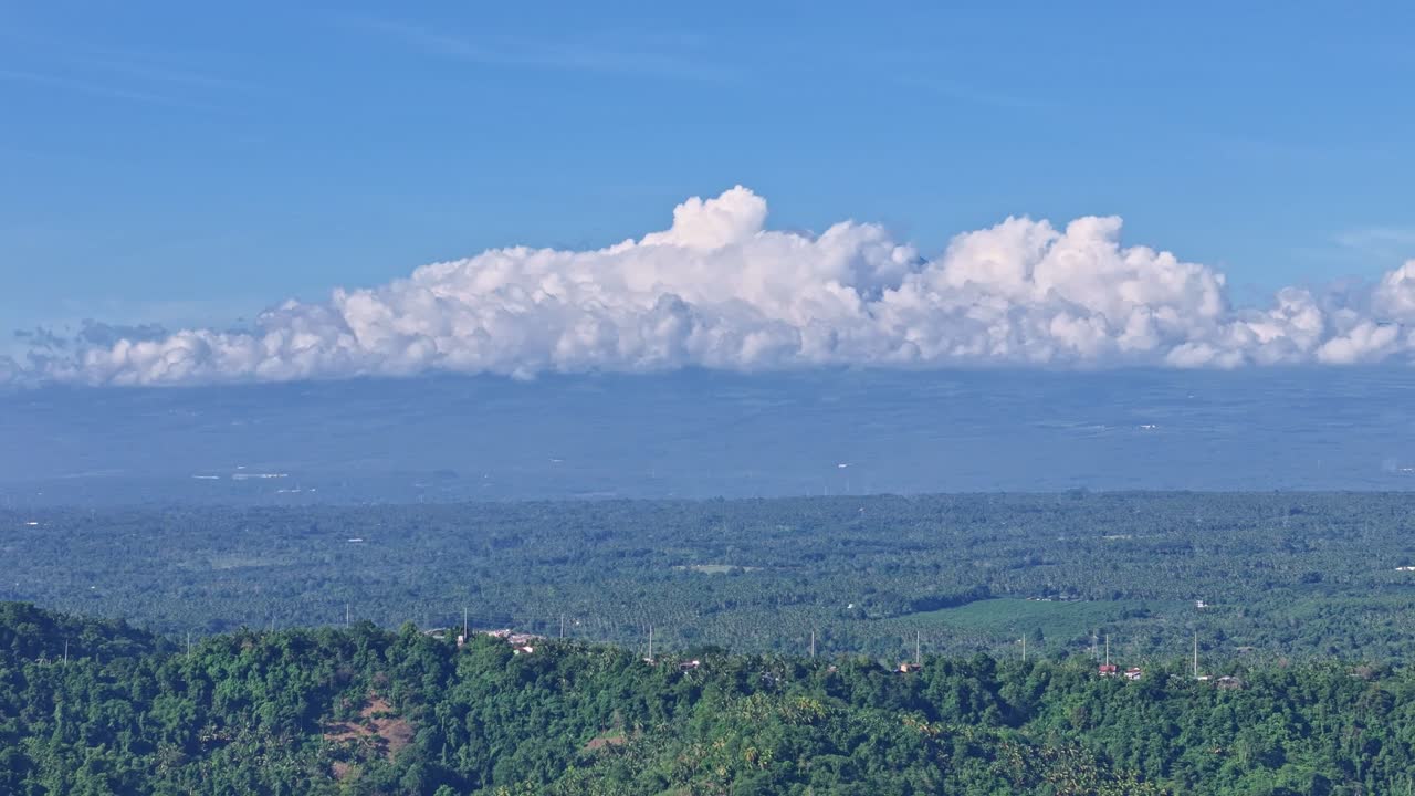 Aerial view across Southern Davao looking toward Mount Apo shrouded in clouds, the Philippines highest mountain