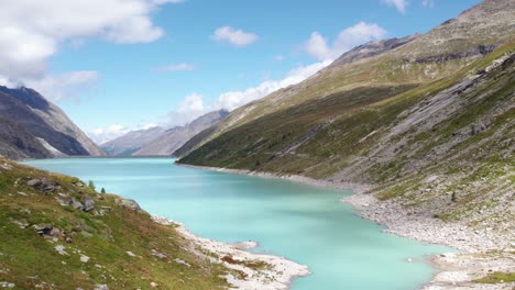 Vuelo-Aéreo-Sobre-El-Lago-Azul-Turquesa-En-Los-Alpes-Suizos-Durante-Los-Hermosos-Meses-De-Verano,-Paraíso-De-Senderismo-En-Mattmark-Suiza