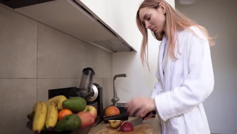 Frau-Schneidet-Apfel-Mit-Einem-Messer-Auf-Einem-Holzschneidebrett,-Um-Saft-Zu-Machen