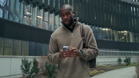 man walking and using a smartphone in a city